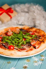 Christmas pizza on the wood board. Holiday celebration pizza. Italian cuisine concept.