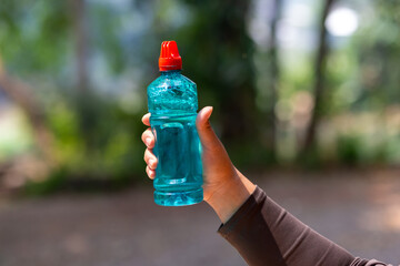 Clear blue green water bottle, the lid is red with a hole in the center for portability, natural...