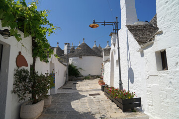 Historic street with Trullo (Trulli) stone houses with conical roof, popular tourist travel destination