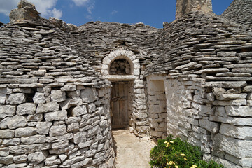 Traditional Trulli house with conical stony roof and wooden door on countryside, Puglia, Italy
