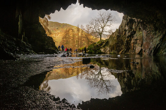 Rydal Cave view outside with a reflection in the water in the lake district on a sunny day. Abandoned slate quarry 
