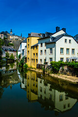 Fototapeta na wymiar Luxembourg city, Luxembourg - July 16, 2019: Scenic view of buildings reflected in Alzette river in the Old Town of Luxembourg city in Europe