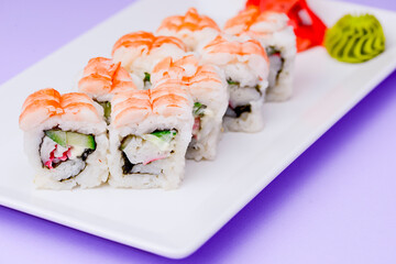 Shrimp sushi close up, Japanese cuisine. Asian cuisine concept. Served on a white plate over purple background