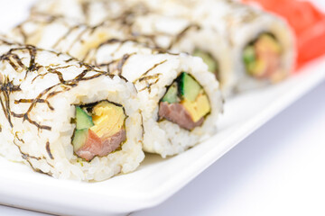 Sushi large set served on a white plate over white background. Traditional Asian Japanese cuisine concept.