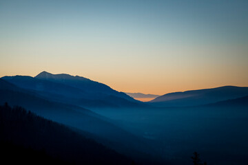 Night is approaching into Tatra National Park, Poland. Pastel colors of the sky and shadow covered areas in the valley. Selective focus on the ridge, blurred background.