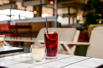Two fruit cocktails dessert in a summer restaurant lounge. Sweet chocolate vanilla dessert and fruit drink.