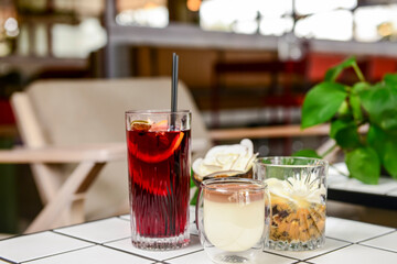 Two fruit cocktails dessert in a summer restaurant lounge. Sweet chocolate vanilla dessert and fruit drink.