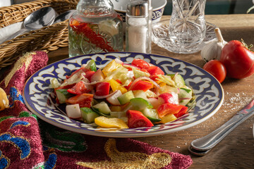 Vegetable salad of pepper, radish and cucumber in a plate with an Uzbek pattern