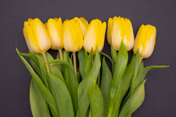 Naklejka premium on a black background a large beautiful bouquet of yellow tulips