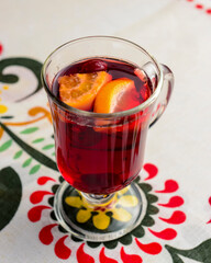 Closeup of mulled wine, in a glass over Traditional Ukrainian tablecloth. Christmas time, winter time.