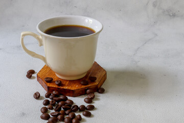 a cup of coffee on wooden tray with coffee beans