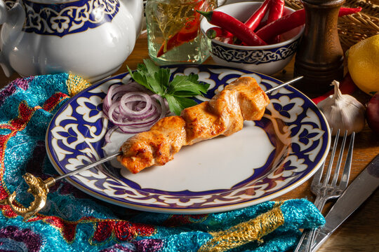 Small portion of chicken shish kebab with red onion and parsley