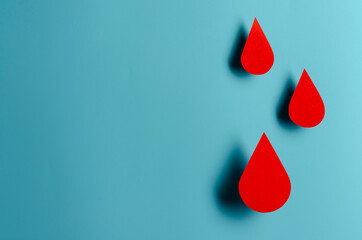 Blood drop symbol on blue background. Hemophilia day, blood donor day.