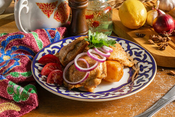 Baked chickenin spices with potatoes, red onions and tomatoes