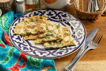 Omelet with green onions in a traditional Uzbek dish