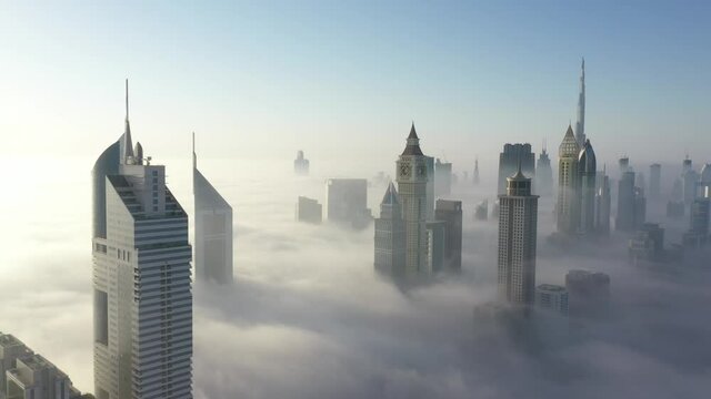 Dubai under clouds of fog. Left to right camera movement. Aerial view.