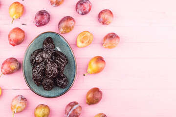 Fresh  prune and dried  prune on wooden board background