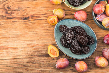 Fresh  prune and dried  prune on wooden board background