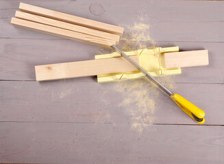 tools for marking and sawing boards on a workbench.
carpentry tool. gray workbench. miter box with a board. 