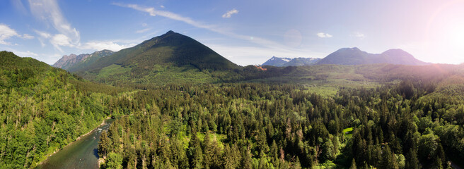 Mountain range and forests in the valley, elevated view of a majestic landscape and a wide river.