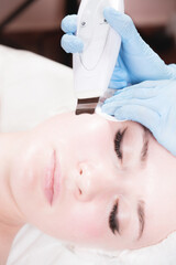 Close-up Professional face cleaning. Mechanical ultrasonic face cleansing procedure. Peeling of the skin of the face.