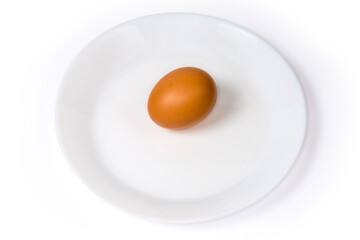 Raw brown chicken egg on dish on a white background