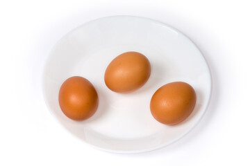 Raw brown chicken eggs on dish on a white background