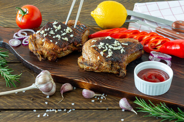 Fresh juicy roasted red meat on wooden board, with spices and vegetables. Restaurant food, delicious dish.