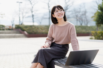 Fototapeta premium 公園でノートパソコンを使う女性