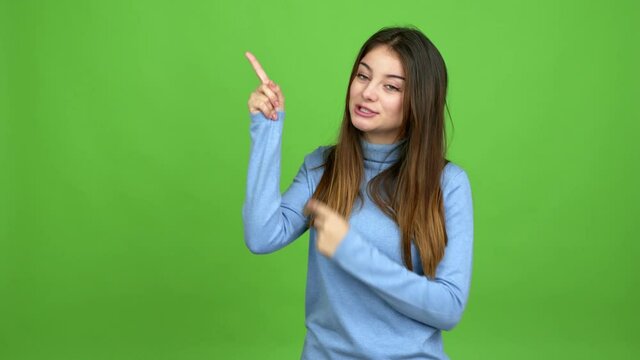 Young caucasian woman pointing a great idea and looking up over isolated background. Green screen chroma key