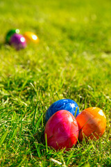Fototapeta premium Colorful painted Easter eggs in the bright fresh green grass, concept for Easter Holliday, spring background with copy space
