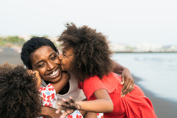 Happy African family having fun on the beach during summer holidays - Afro people enjoying vacation...