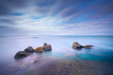 Fototapeta na wymiar Rocks and soft sea, long exposure photography landscape.