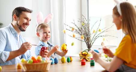 Obraz na płótnie Canvas Happy family painting Easter eggs together