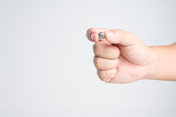 Hand holding round lithium button cell battery