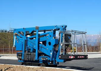 Small tracked cherry picker, folded waiting for use.