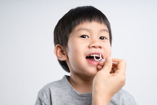 Asian boy about 4 years old is being cleaned teeth with dental floss