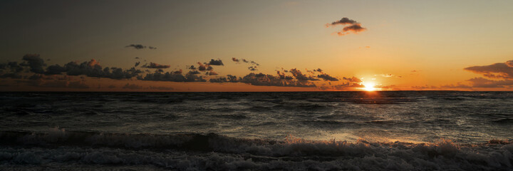 Waves in the sea with sunset as a panorama
