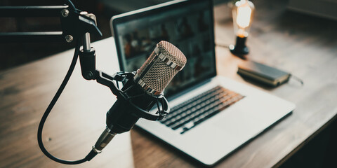 Home studio podcast interior. Microphone, laptop and on air lamp on the table, close-up - obrazy, fototapety, plakaty