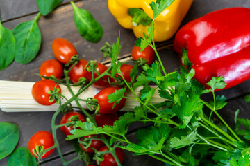 Top view colorful green organic vegetables with spaghetti pasta on wooden table.