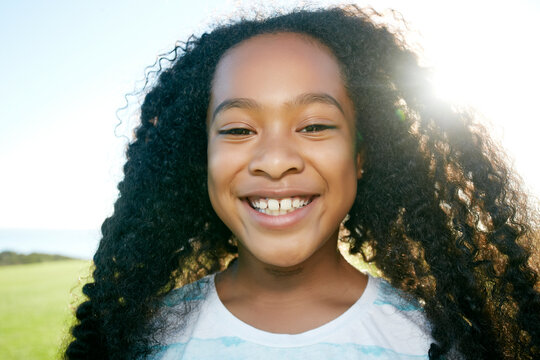 Young mixed race girl with long curly black hair, smiling