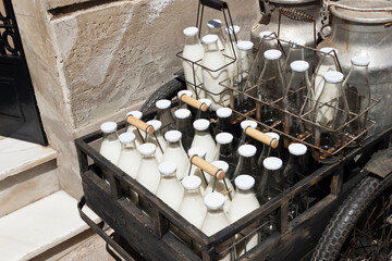 Bottles and aluminum cans of milk for delivery in vintage milkman bicycle