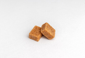 two pieces Brown cane sugar cubes isolated on white background