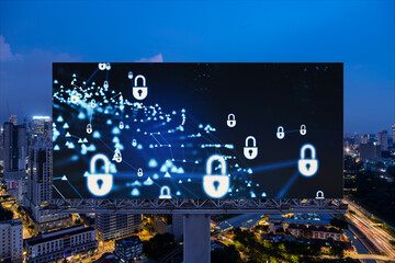 Padlock icon hologram on road billboard over panorama city view of Kuala Lumpur at night to protect business, Malaysia, Asia. The concept of information security shields.