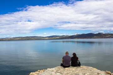 Fototapeta na wymiar The young couple enjoys the view of the Danube river. At this place, in Golubac, Serbia, the Danube is the widest in its entire course.