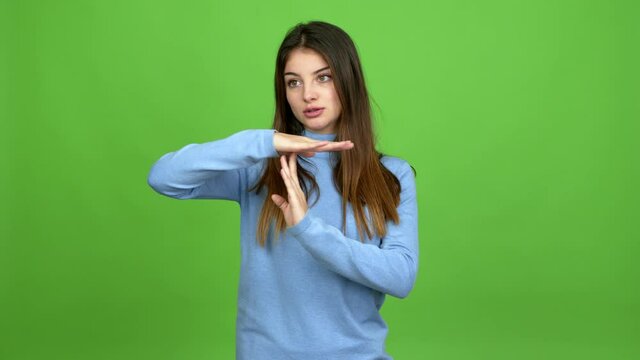 Young caucasian woman doing time out gesture over isolated background. Green screen chroma key