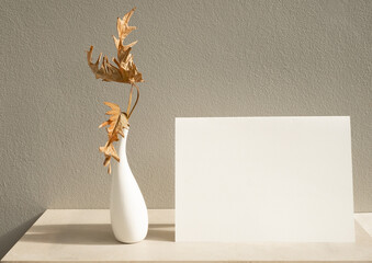 Mock up invitation white cards and exotic Philodendron dry leaves in modern vase on table with...