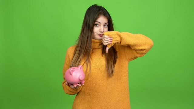 Young caucasian woman happy and holding a piggybank over isolated background. Green screen chroma key