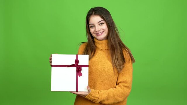 Young caucasian woman happy and holding a gift over isolated background. Green screen chroma key
