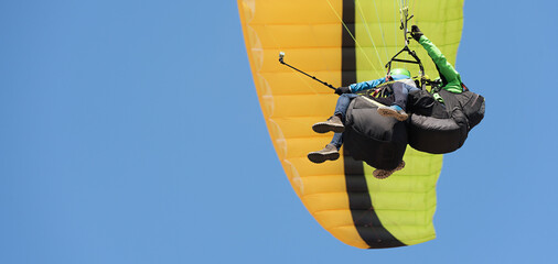 Tandem paragliding on background of blue summer sky